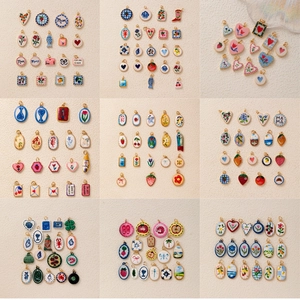 Detailed grid of assorted hand-painted ceramic pendants featuring fruit and animal motifs