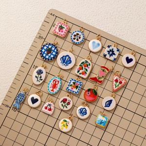 Macro shot of colorful enamel fruit and lobster pendants on a grid display board