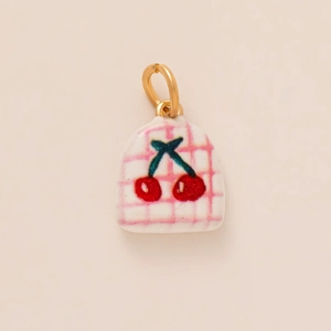 Detail of pink plaid cherry pendant with gold ring for DIY jewelry making