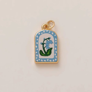 Detail of gold-edged pendant with lily of the valley pattern and sky blue polka dots