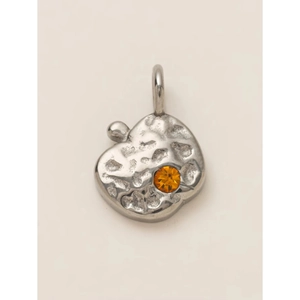 Close-up of hammered 18K gold-plated steel fruit pendant with faceted orange zircon