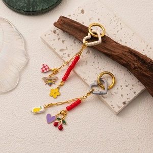 Détail de crochets cœur plaqués or 18K avec perles rouges et pendentifs en cristal