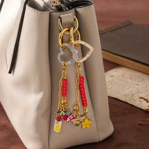 Bijou de sac DIY plaqué or 18K avec pendentifs en émail et abeilles sur un sac à main en cuir
