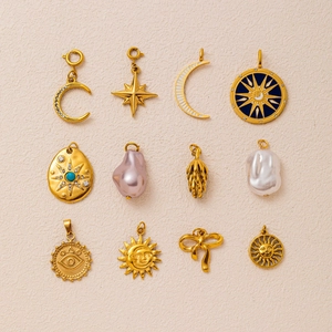 Macro detail of assorted 18K gold-plated star, moon, and pearl pendants for jewelry DIY