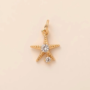Macro shot of a gold starfish pendant with sparkling cubic zirconia and beaded texture