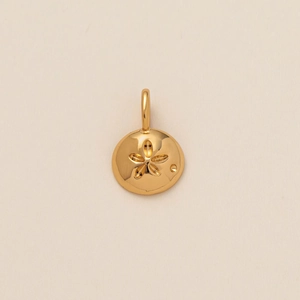 Detailed macro view of a polished gold starfish pendant with a central cutout design