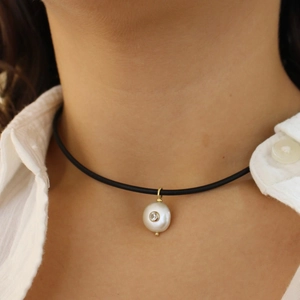 Minimalist black cord choker necklace with white pearl pendant and small inset gemstone
