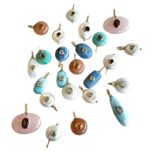 Collection of multi-material gemstone pendants with gold plated rings and colored stones