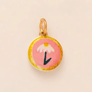 Detailed view of flower charm with pink enamel, white petals, and 18K gold plated loop