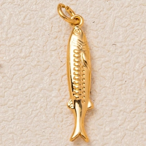 Detailed macro view of gold-plated fish pendant with embossed scale textures