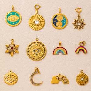 Macro detail of 12 gold plated stainless steel evil eye and rainbow charms on sand texture