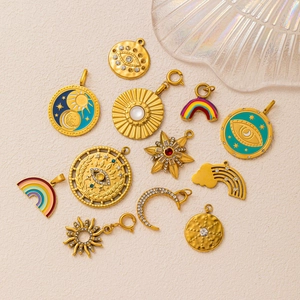 Detail view of 18K gold plated stainless steel charms including celestial and evil eye motifs