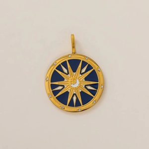 Detailed macro view of 18K gold star and moon pendant with blue and white enamel