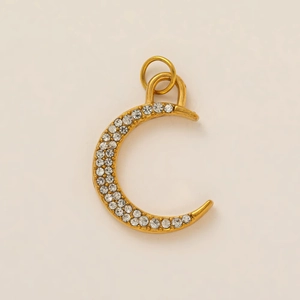 Detailed close-up of C-shaped gold-plated pendant with sparkling cubic zirconia inlay