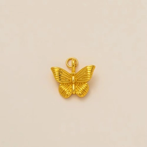 Detailed close-up of a 18K gold butterfly pendant with fine textured wing engravings