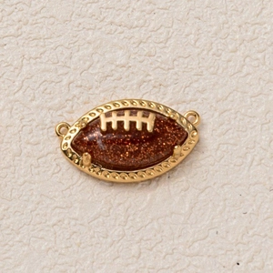 Detail of American football charm with gold metal frame and brown glitter inlay
