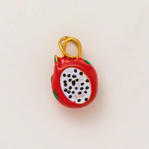 Détail d'un pendentif fruit du dragon en émail rouge avec anneaux en métal doré
