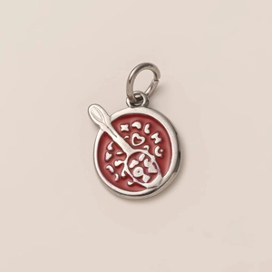 Macro detail of round ice cream charm with red enamel and silver heart spoon engraving