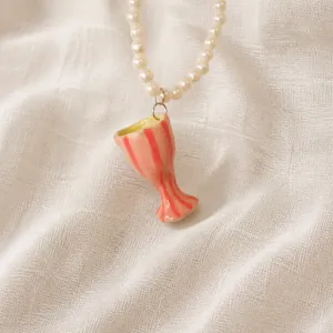 Detail of cute pink striped cup pendant on a white pearl necklace for women