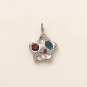Detailed view of silver polished star pendant with red, blue and pink zircon gemstones