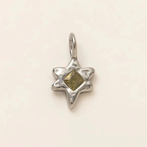 Detail of hammered silver star pendant with emerald-cut green gemstone center