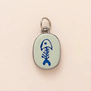 Detailed close-up of oval stainless steel fishbone charm with green enamel finish