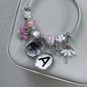 Pink butterfly bead bracelet with a silver photo locket and personalized letter charm