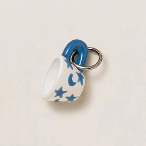 Macro shot of 18K gold plated ceramic mini mug charm with blue star and moon patterns