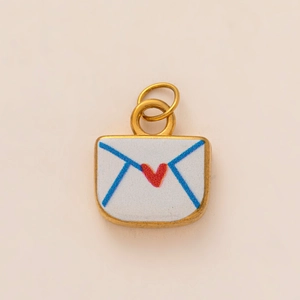 Close-up of a gold envelope pendant with blue outlines and a small red heart detail