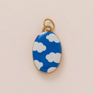 Detail of oval blue enamel pendant with white cloud pattern and 18K gold plated frame