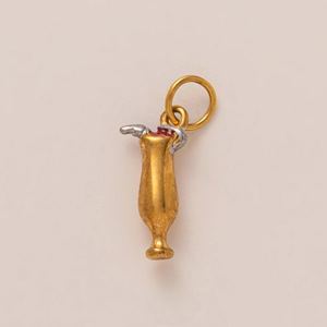 Vue détaillée d'un pendentif cocktail doré avec paille argentée et cerise rouge