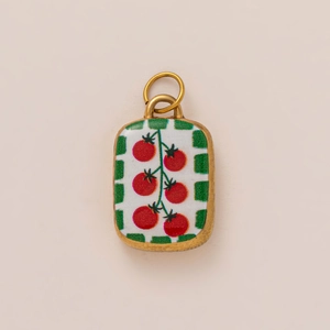 Detailed macro view of an 18K gold plated sardine can pendant with red tomato pattern
