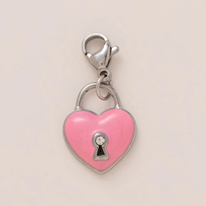 Détail macro d'un pendentif cadenas cœur en émail rose avec un accent en zircon
