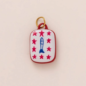 Close-up of a rectangular 18K gold plated pendant with a blue fish and pink stars
