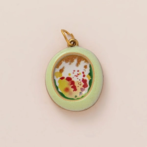 Detailed macro view of an oval vintage art pendant with light green matte frame and golden ring