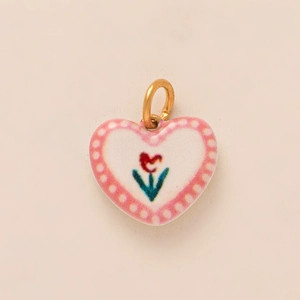 Detail view of heart-shaped ceramic pendant with tulip floral pattern and gold metal ring