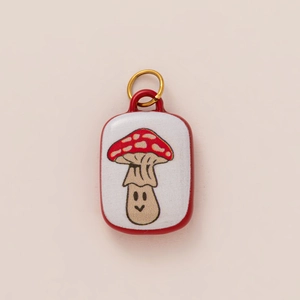 Detail showing a rectangular mushroom pendant with red spots and 18K gold plated ring