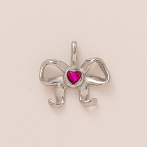 Detailansicht der silbernen Schleife mit poliertem Finish und rosa Herz-Edelstein