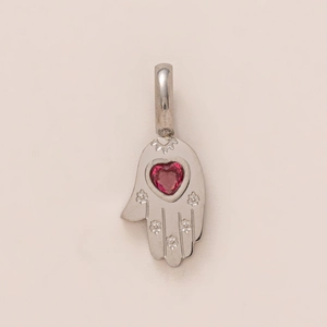 Detailaufnahme der Hamsa-Hand mit rotem Herz-Edelstein und floralen Gravuren