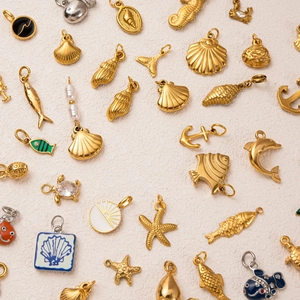 Colección de colgantes marinos de acero inoxidable en oro de 18K con estrellas de mar y conchas