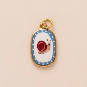 Close-up of golden oval pendant with a cute snail illustration and enamel finish