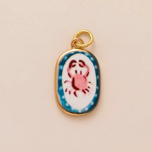 Pendaglio ovale a granchio dorato con illustrazione rosa e decoro a pois blu