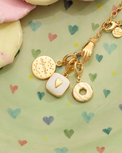Primo piano dettagliato del bracciale placcato oro 18K con ciondoli biscotto, cuore e donut