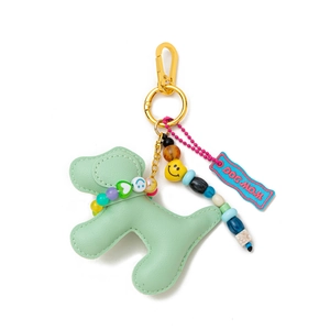 Detail of mint green leather dog keychain with gold hook and 'DOG MOM' woven tag
