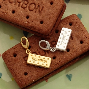 Ciondoli a forma di biscotto bourbon placcati oro 18K in oro e argento su piatto decorato