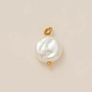 Detail van barokke parelhanger met 18K vergulde metalen ring op beige achtergrond