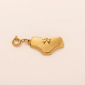 Detailed view of a gold-plated panty-shaped charm with bow relief and spring clasp