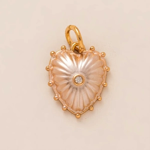 Detailed close-up of a heart pendant with pink pearlescent inlay and a central clear gemstone