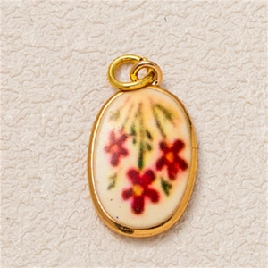 Vista macro de un colgante ovalado chapado en oro con motivos florales rojos y esmalte