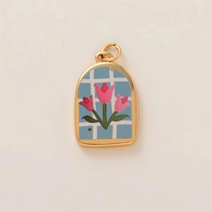Colgante de arco bañado en oro con tulipanes rosas y diseño esmaltado de cuadros azul